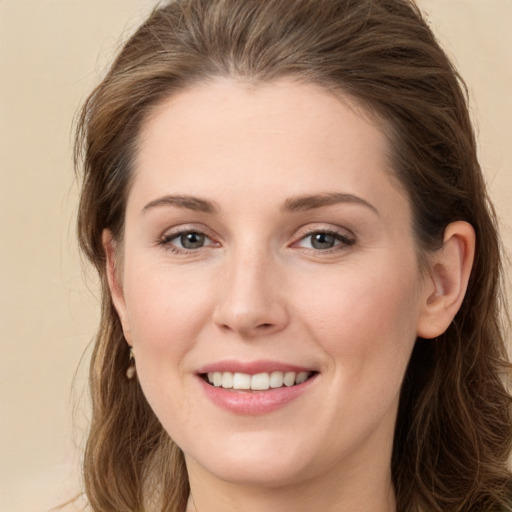 Joyful white young-adult female with long  brown hair and grey eyes