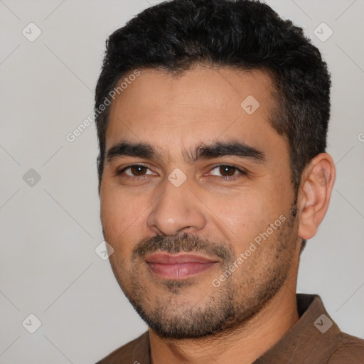 Joyful latino young-adult male with short  black hair and brown eyes