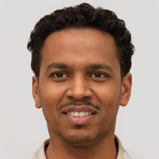 Joyful black young-adult male with short  black hair and brown eyes