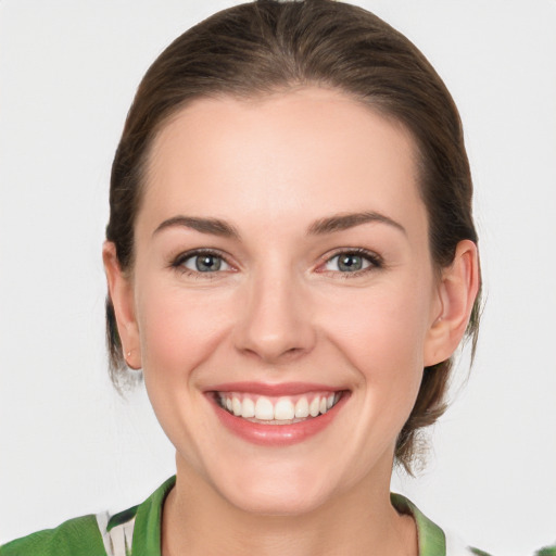 Joyful white young-adult female with medium  brown hair and green eyes