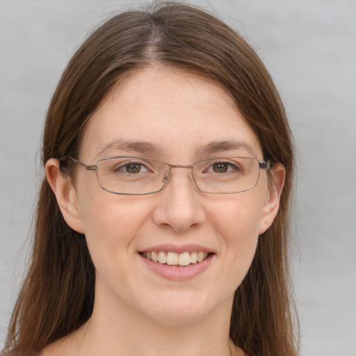 Joyful white adult female with long  brown hair and grey eyes