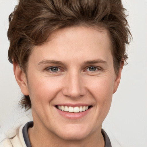 Joyful white young-adult female with short  brown hair and grey eyes