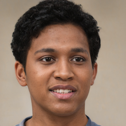 Joyful black young-adult male with short  brown hair and brown eyes