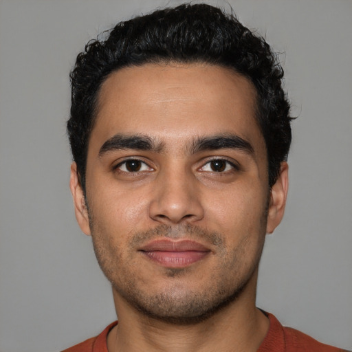 Joyful latino young-adult male with short  black hair and brown eyes