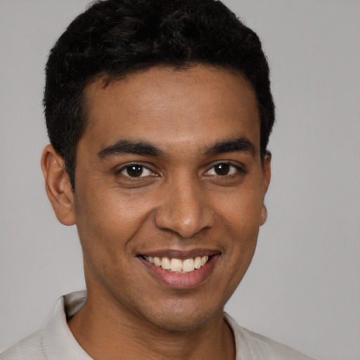 Joyful latino young-adult male with short  brown hair and brown eyes
