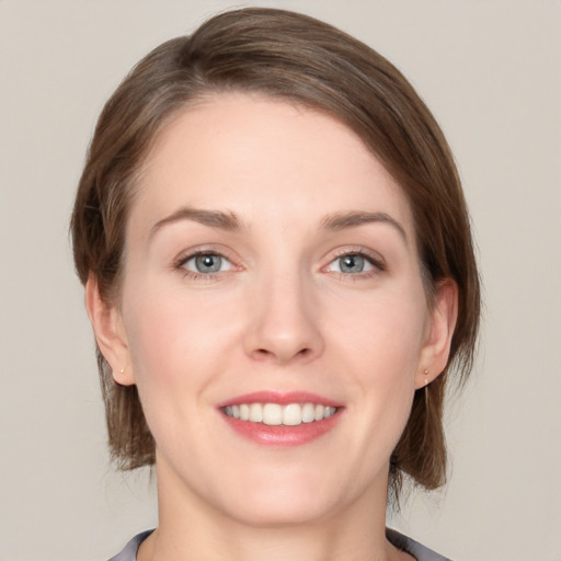 Joyful white young-adult female with medium  brown hair and grey eyes