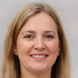 Joyful white adult female with long  brown hair and brown eyes