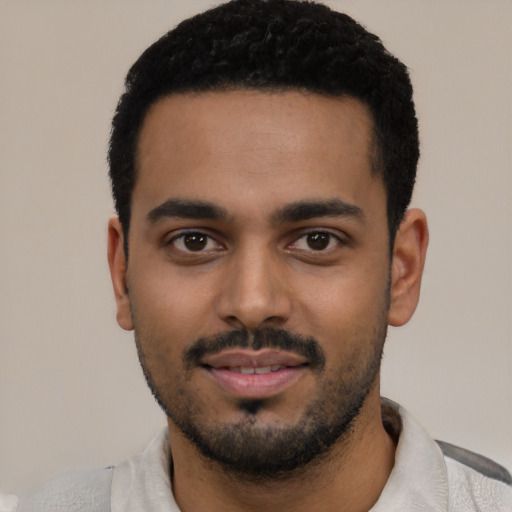 Joyful latino young-adult male with short  black hair and brown eyes