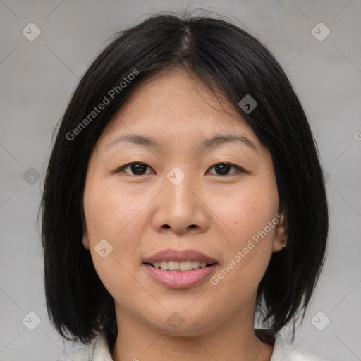 Joyful asian adult female with medium  brown hair and brown eyes