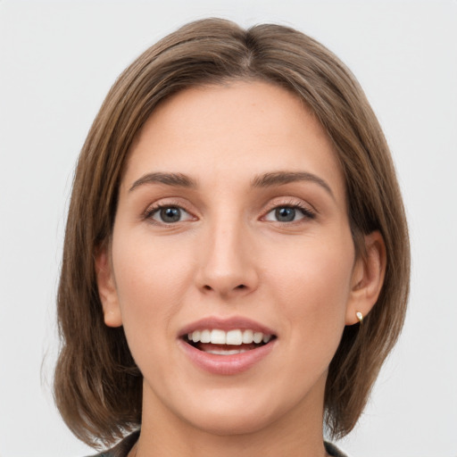 Joyful white young-adult female with long  brown hair and green eyes