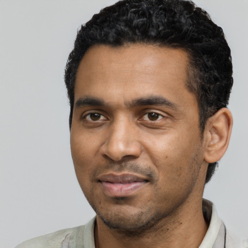 Joyful black young-adult male with short  black hair and brown eyes