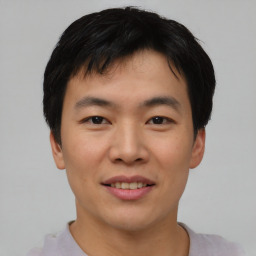 Joyful asian young-adult male with short  black hair and brown eyes