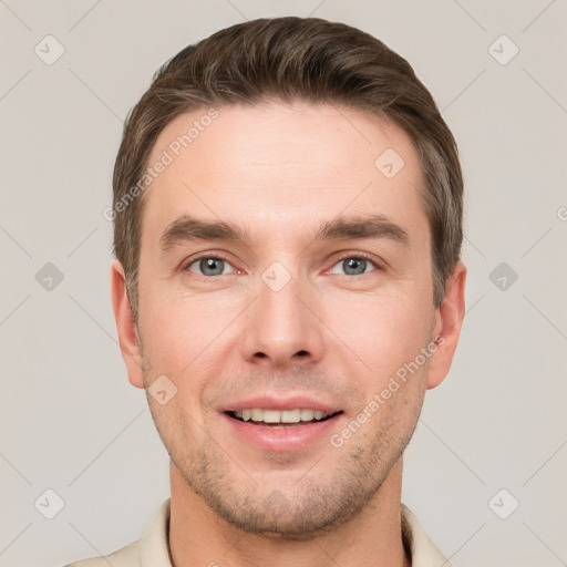 Joyful white young-adult male with short  brown hair and grey eyes