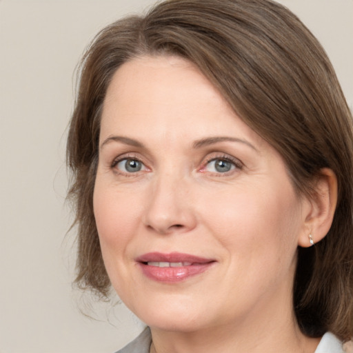 Joyful white adult female with medium  brown hair and grey eyes