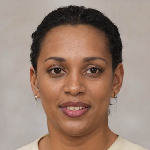 Joyful black adult female with short  black hair and brown eyes