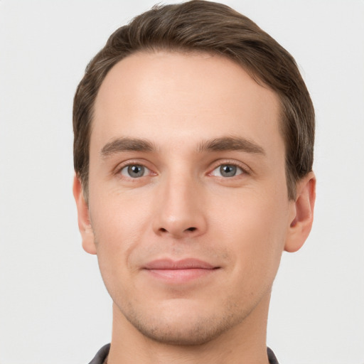 Joyful white young-adult male with short  brown hair and grey eyes