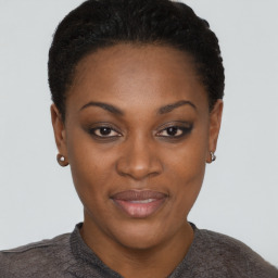 Joyful black young-adult female with short  black hair and brown eyes