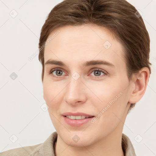 Joyful white young-adult female with short  brown hair and grey eyes