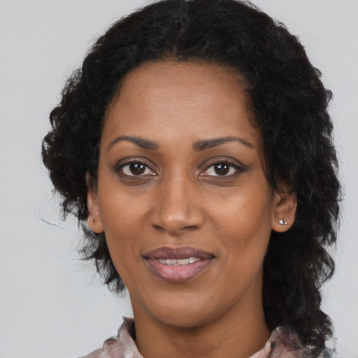 Joyful black adult female with long  black hair and brown eyes