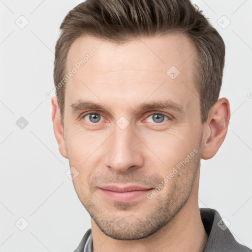 Joyful white young-adult male with short  brown hair and grey eyes