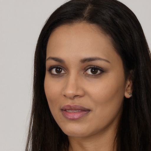 Joyful black young-adult female with long  brown hair and brown eyes