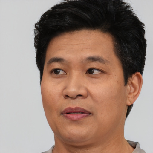 Joyful asian adult male with short  black hair and brown eyes
