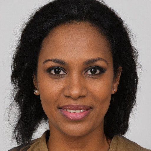 Joyful black young-adult female with long  brown hair and brown eyes