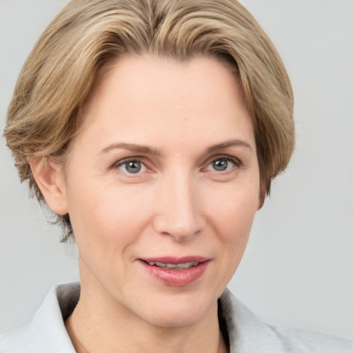 Joyful white adult female with medium  brown hair and grey eyes