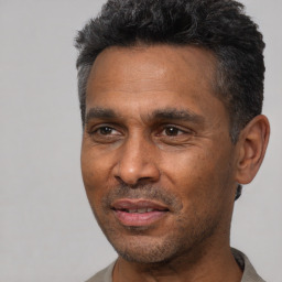 Joyful black adult male with short  black hair and brown eyes