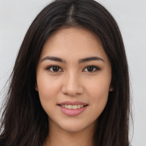 Joyful latino young-adult female with long  brown hair and brown eyes
