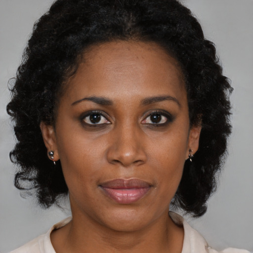 Joyful black young-adult female with medium  brown hair and brown eyes