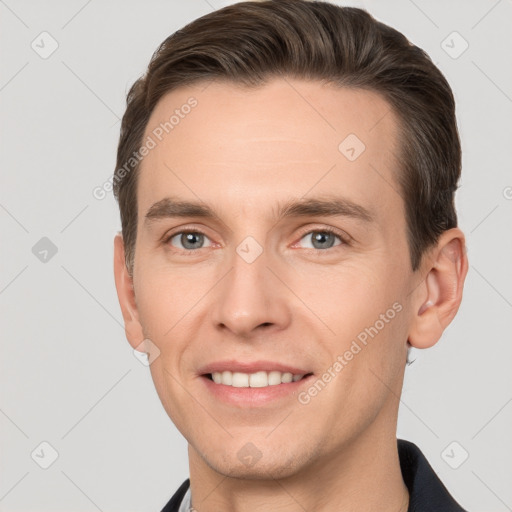 Joyful white young-adult male with short  brown hair and grey eyes