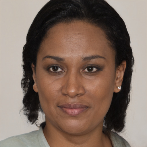 Joyful black adult female with medium  brown hair and brown eyes