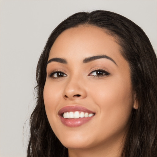 Joyful latino young-adult female with long  black hair and brown eyes