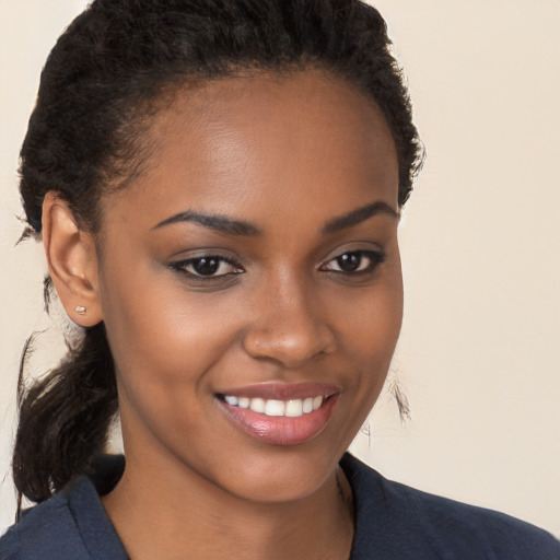 Joyful black young-adult female with long  brown hair and brown eyes