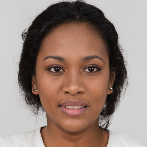 Joyful black young-adult female with long  brown hair and brown eyes