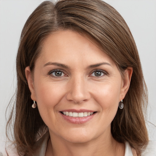 Joyful white young-adult female with medium  brown hair and grey eyes