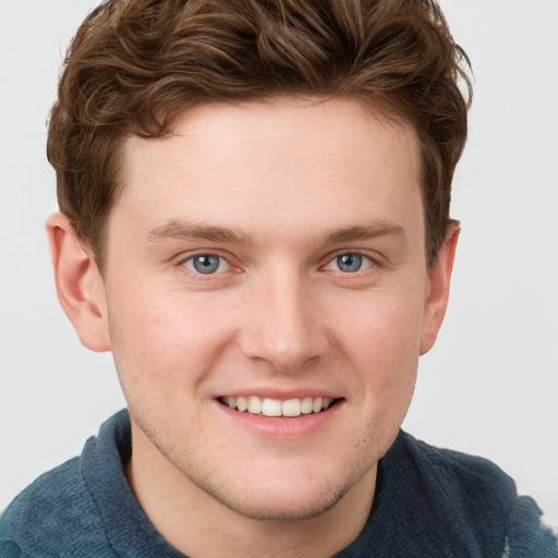 Joyful white young-adult male with short  brown hair and blue eyes