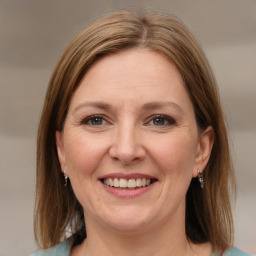 Joyful white adult female with medium  brown hair and grey eyes