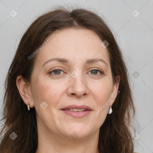 Joyful white adult female with long  brown hair and grey eyes