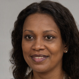 Joyful black adult female with long  brown hair and brown eyes