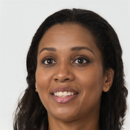 Joyful black young-adult female with long  brown hair and brown eyes