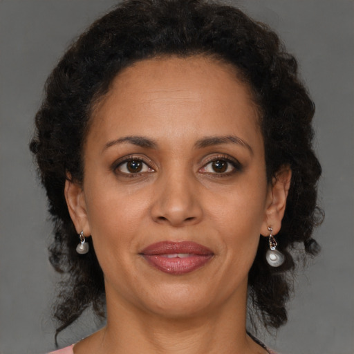 Joyful latino adult female with medium  brown hair and brown eyes
