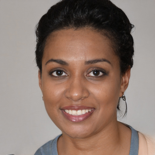 Joyful black young-adult female with short  black hair and brown eyes