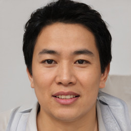 Joyful asian young-adult male with short  black hair and brown eyes