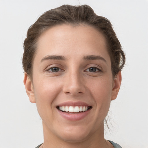 Joyful white young-adult female with short  brown hair and grey eyes