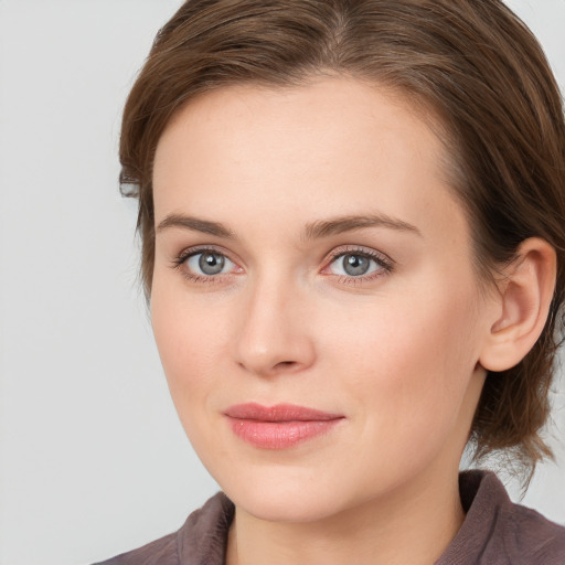 Joyful white young-adult female with medium  brown hair and grey eyes