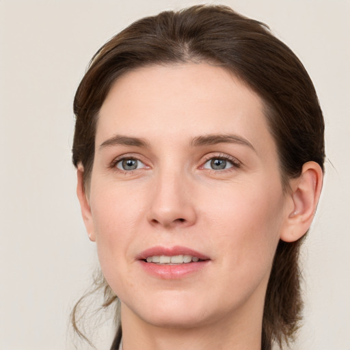 Joyful white young-adult female with medium  brown hair and grey eyes