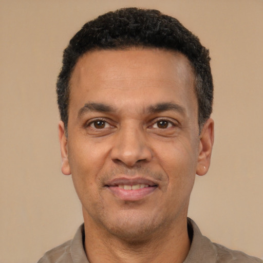Joyful latino adult male with short  black hair and brown eyes