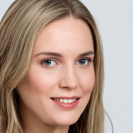 Joyful white young-adult female with long  brown hair and blue eyes